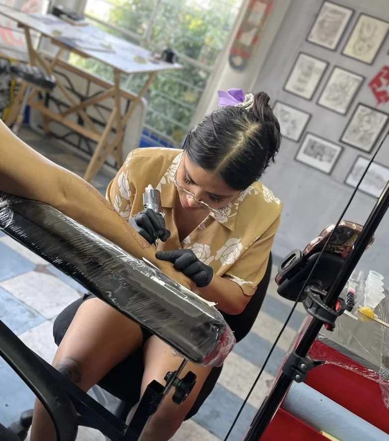 Jacky Lossan trabajando un tatuaje realista en el brazo de un cliente en Tláhuac, CDMX
